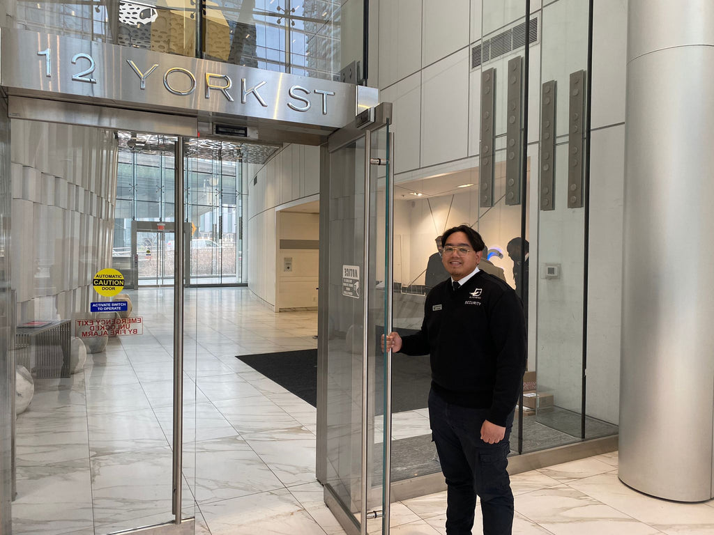 Uniformed Blackbird security guard opening door
