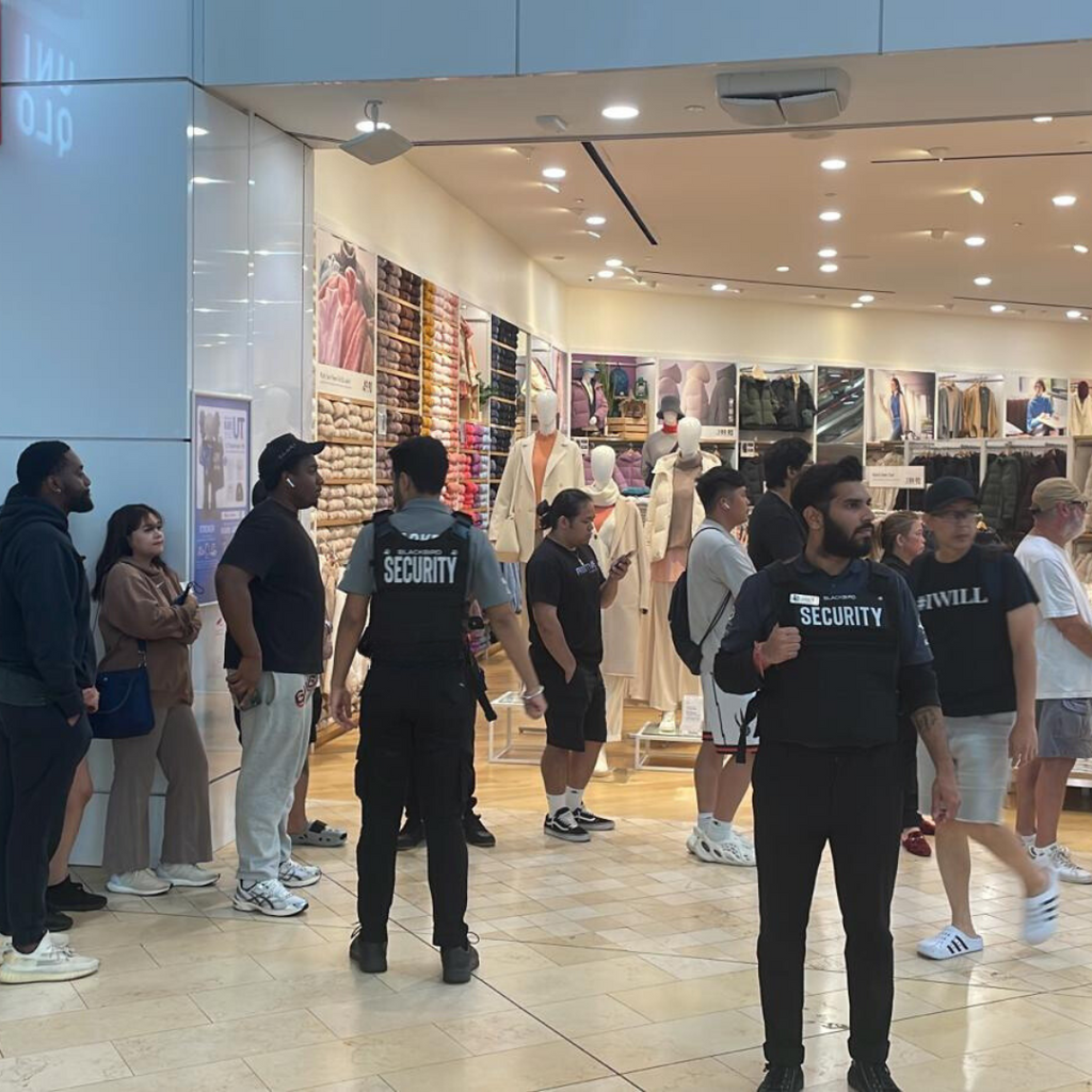 Blackbird Security guard assisting with line control at retail store