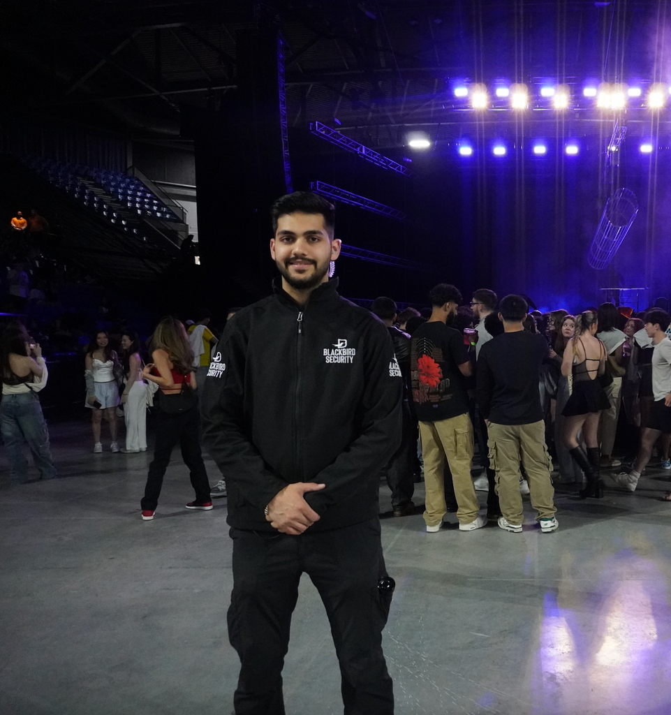 Blackbird Security guard stands on guard at an indoor concert venue in Vancouver.