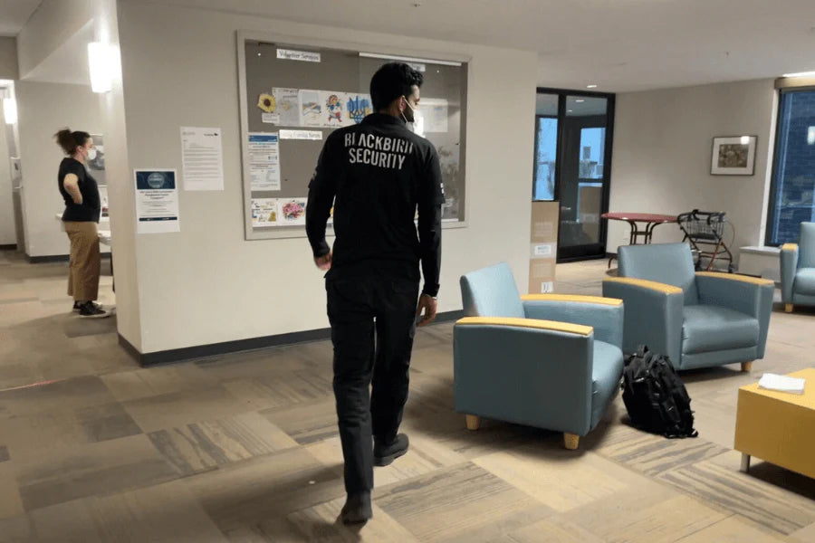 A Blackbird Security guard walks through a common space at Holy Family Home