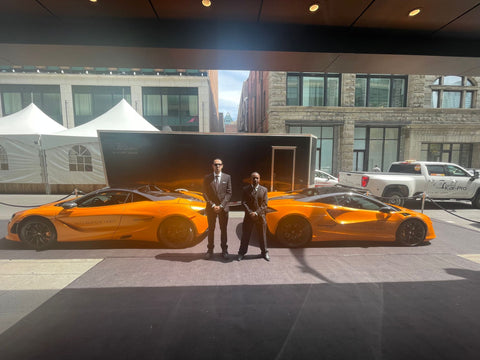 Two Plained Clothes Blackbird security guard standing in front of two mcclaren cars