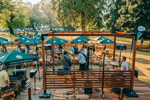 people in park attending an event with tables and umbrella