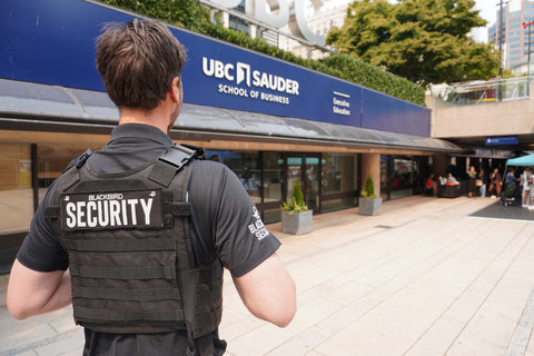 Uniformed Blackbird security guard standing outside UBC Saunders School of Business