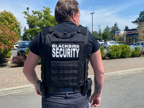 Uniformed Blackbird security guard on street
