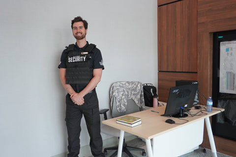 Uniformed Blackbird security guards standing in front of desk with computer screen