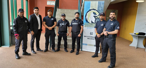 Uniformed Blackbird security guards standing in front of banner
