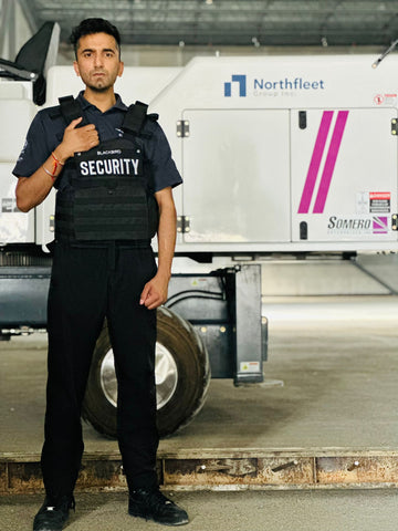 Blackbird security guard in front of construction site equipment