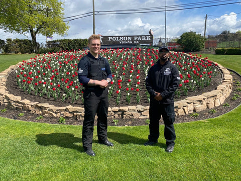 Two Uniformed Blackbird security guards in front of garden