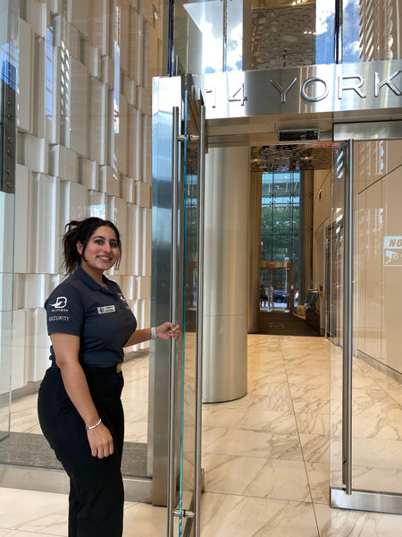 Uniformed Blackbird security guard opening door