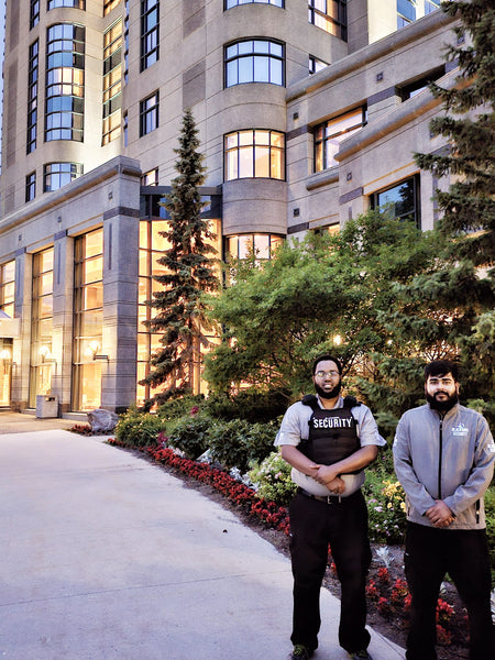 Two Uniformed Blackbird security guards standing in front of building