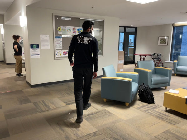 Uniformed Blackbird security guard patrolling lobby of office