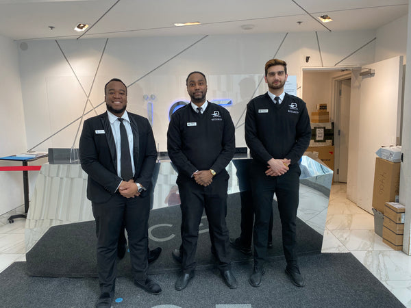 Three Uniformed Blackbird security guards standing in front of condo reception desk