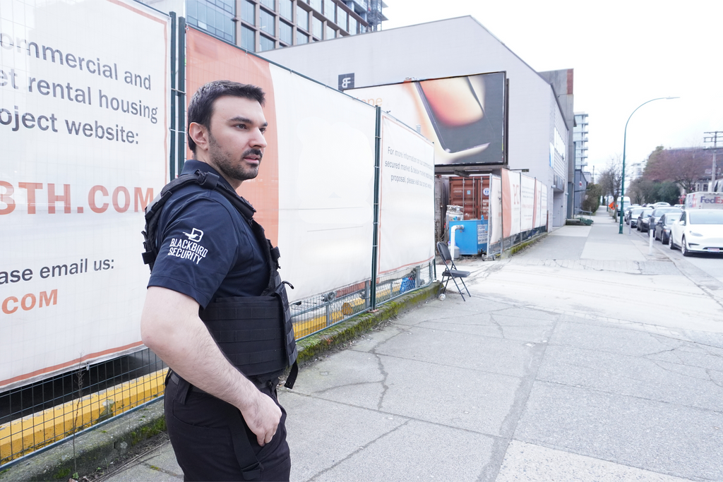 Uniformed Blackbird security guard standing in front of construction site