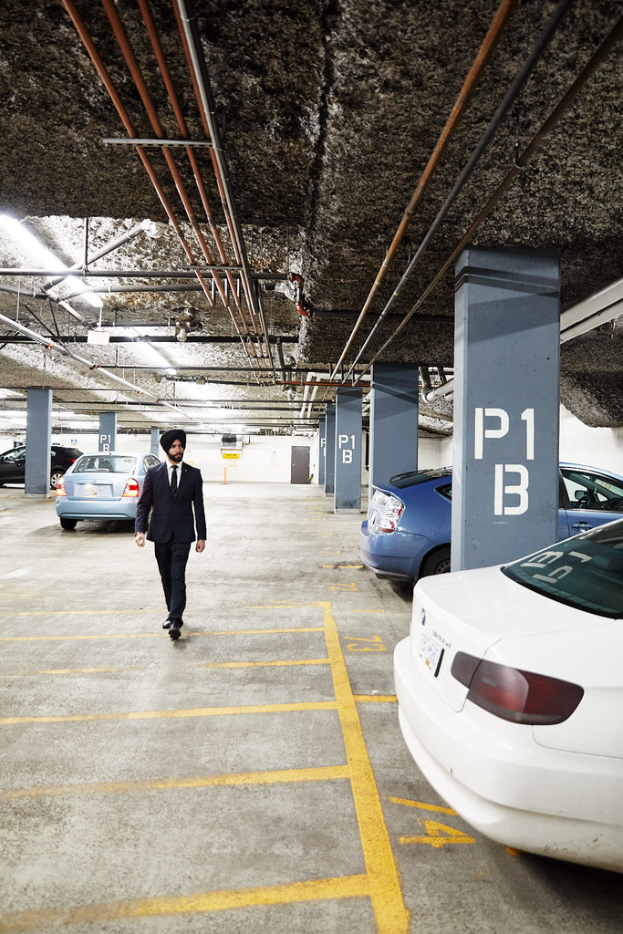 Uniformed Blackbird Security suit and tie security guard patrolling an underground parking lot in a residential building