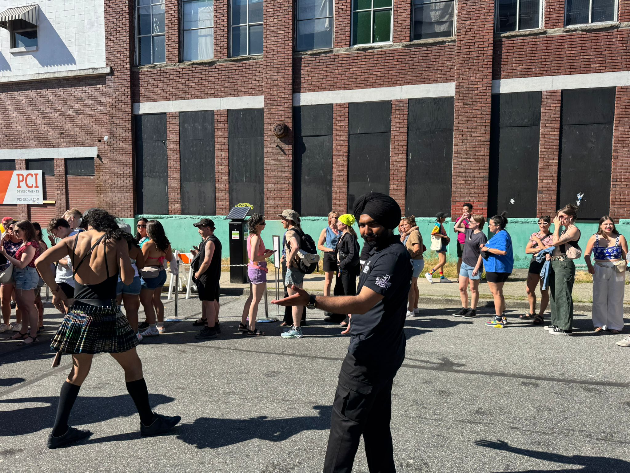 A Blackbird Security event security guard at The Birdhouse in Vancouver conducts line management during Pride weekend.