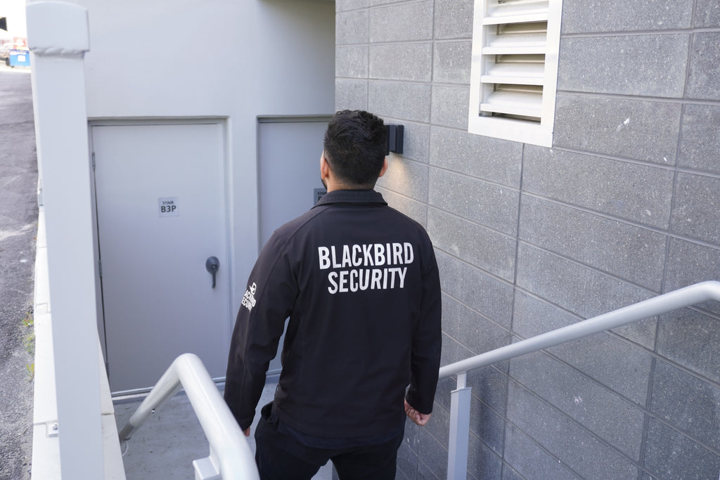 Condominium security guard walking down a flight of exterior steps to a maintenance door.