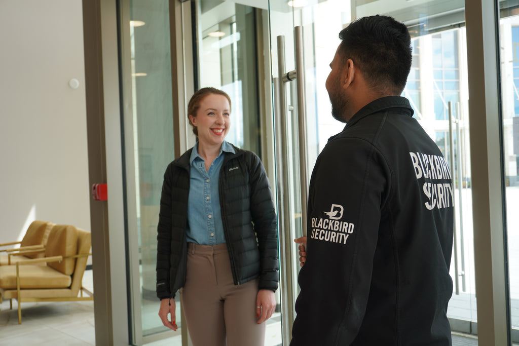 Condo security guard greets a woman at the building's front entrance