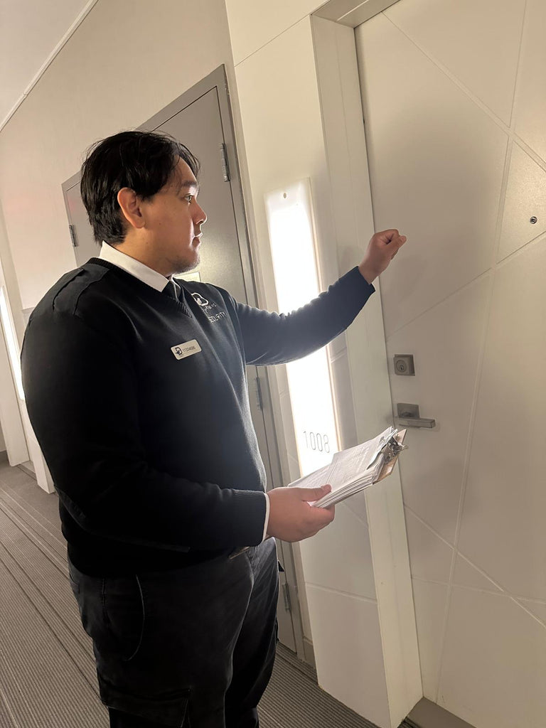 Security personnel from Blackbird Security knocking on a door while holding a clipboard