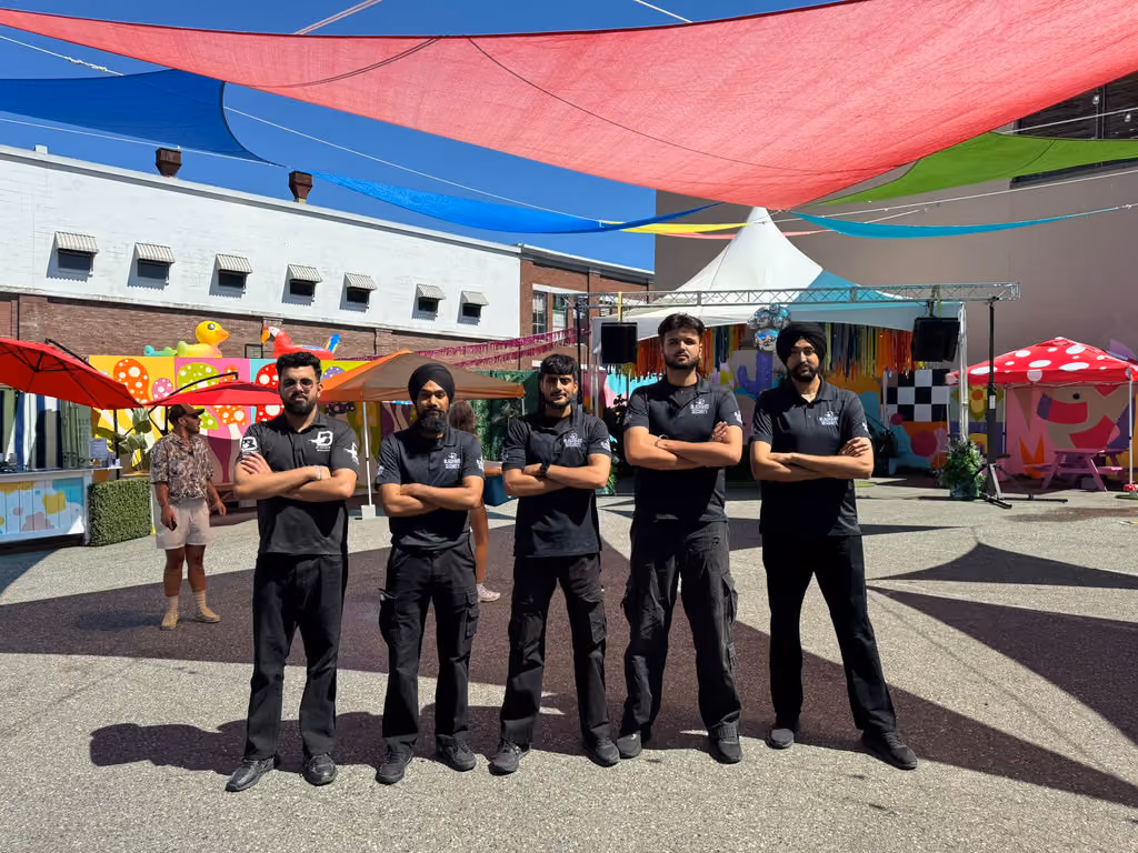Five Blackbird Security event security guards stand in a line, facing the camera, conducting event security in Vancouver at The Birdhouse during Pride weekend.