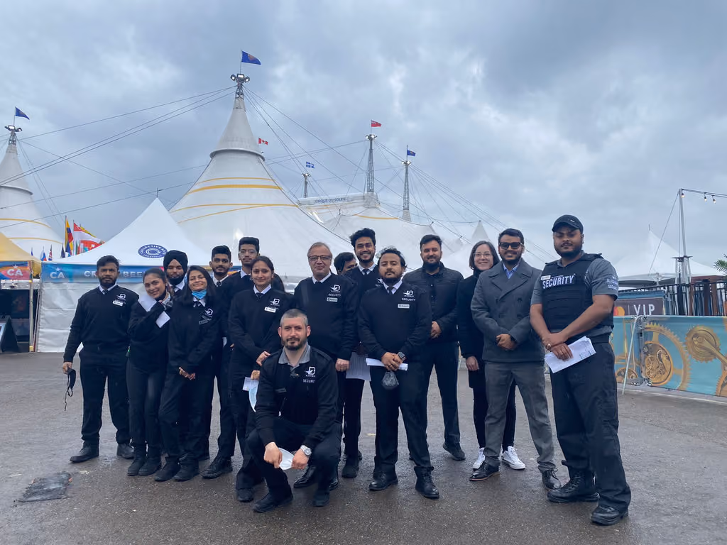 A large group of Blackbird Security event security guards stand outside of a Cirque du Soleil tent in Toronto.