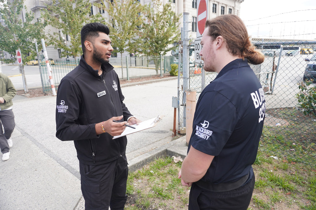 Two Blackbird security guards speaking to each other