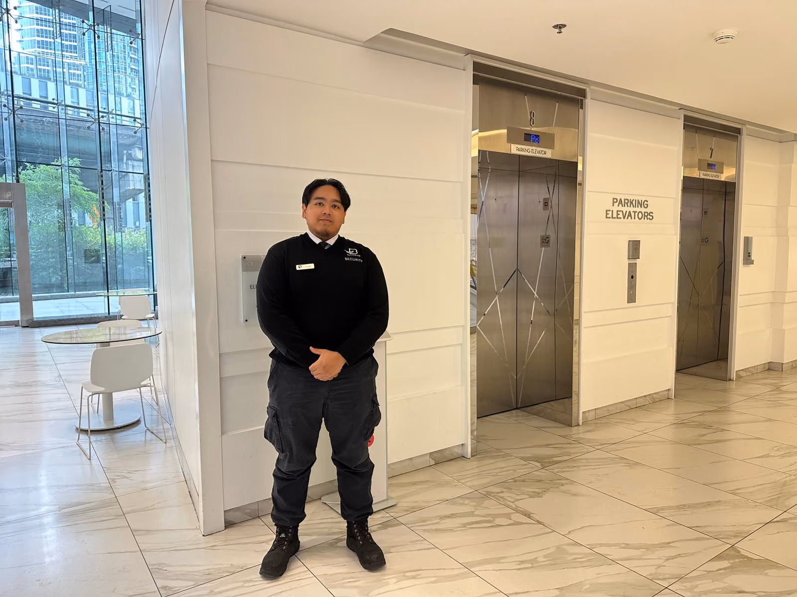 Uniformed Blackbird Security guard standing in a building lobby