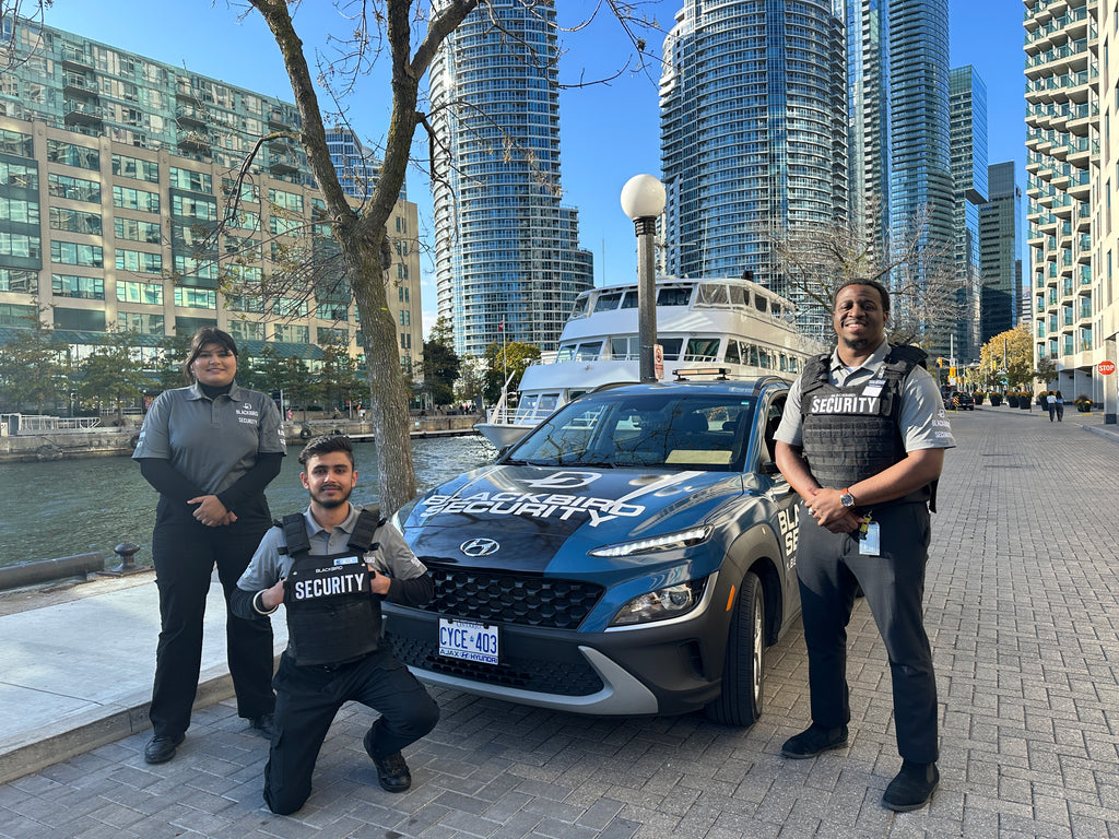 Blackbird Security team and patrol car in front of Toronto buildings and a boat