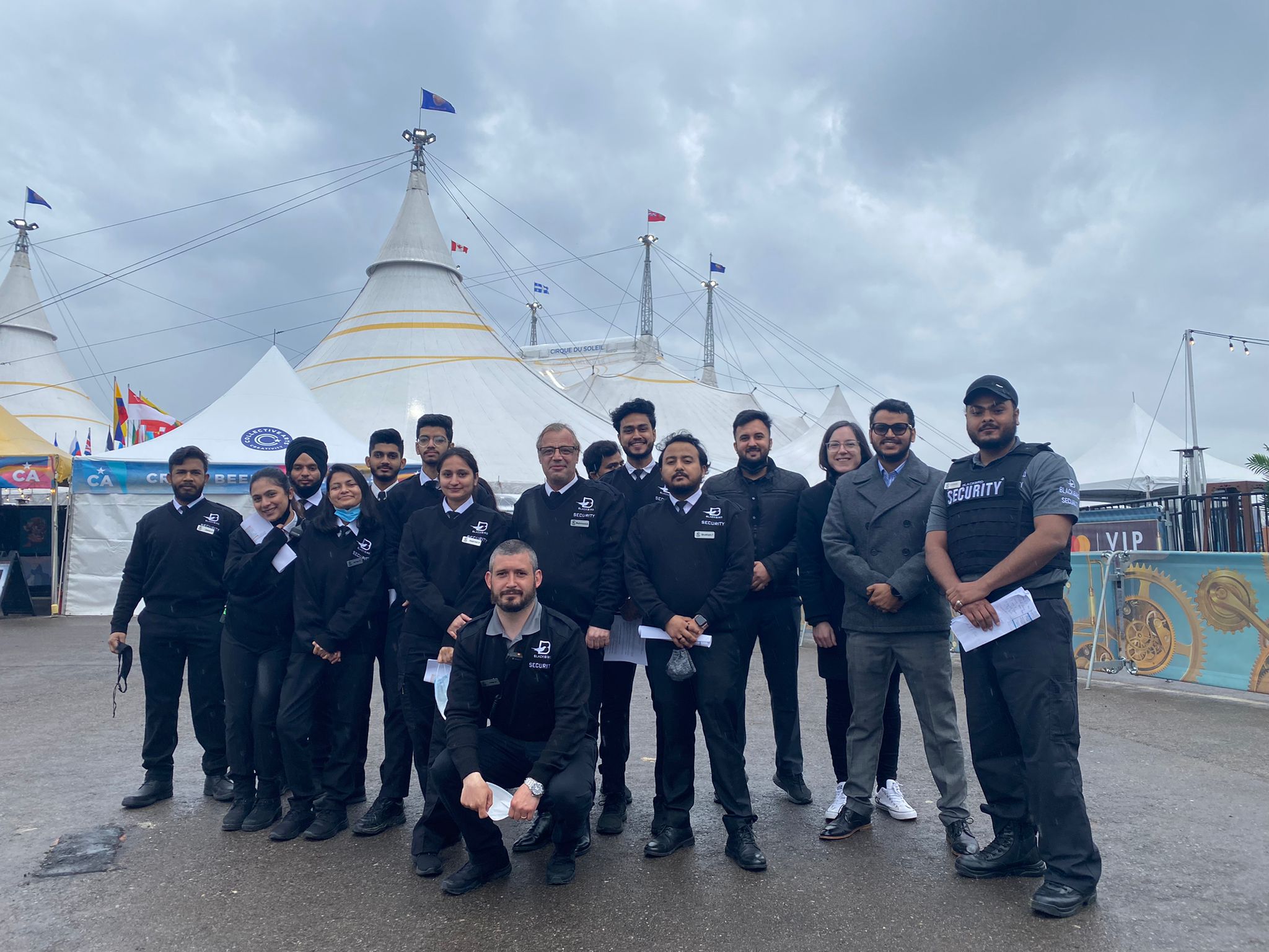 A group of Blackbird Security event security guards pose outside of Cirque du Soleil tents.