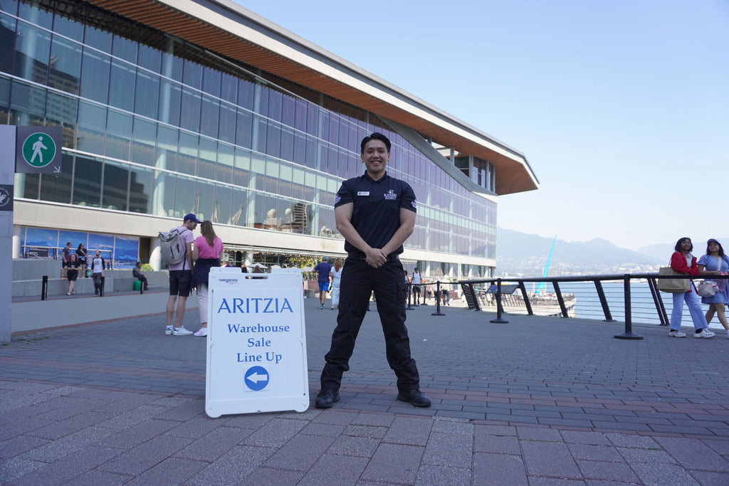 A Blackbird Security guard in uniform stands outside the Aritzia warehouse sale in Vancouver
