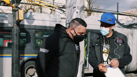 Uniformed Blackbird security guard giving help to person on street