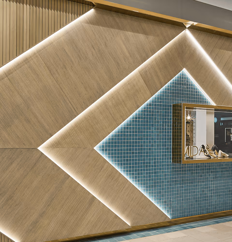 Modern interior wall with geometric wood panels and blue tiled diamond shape featuring a display case with shoes and the word 'VIDAS'.