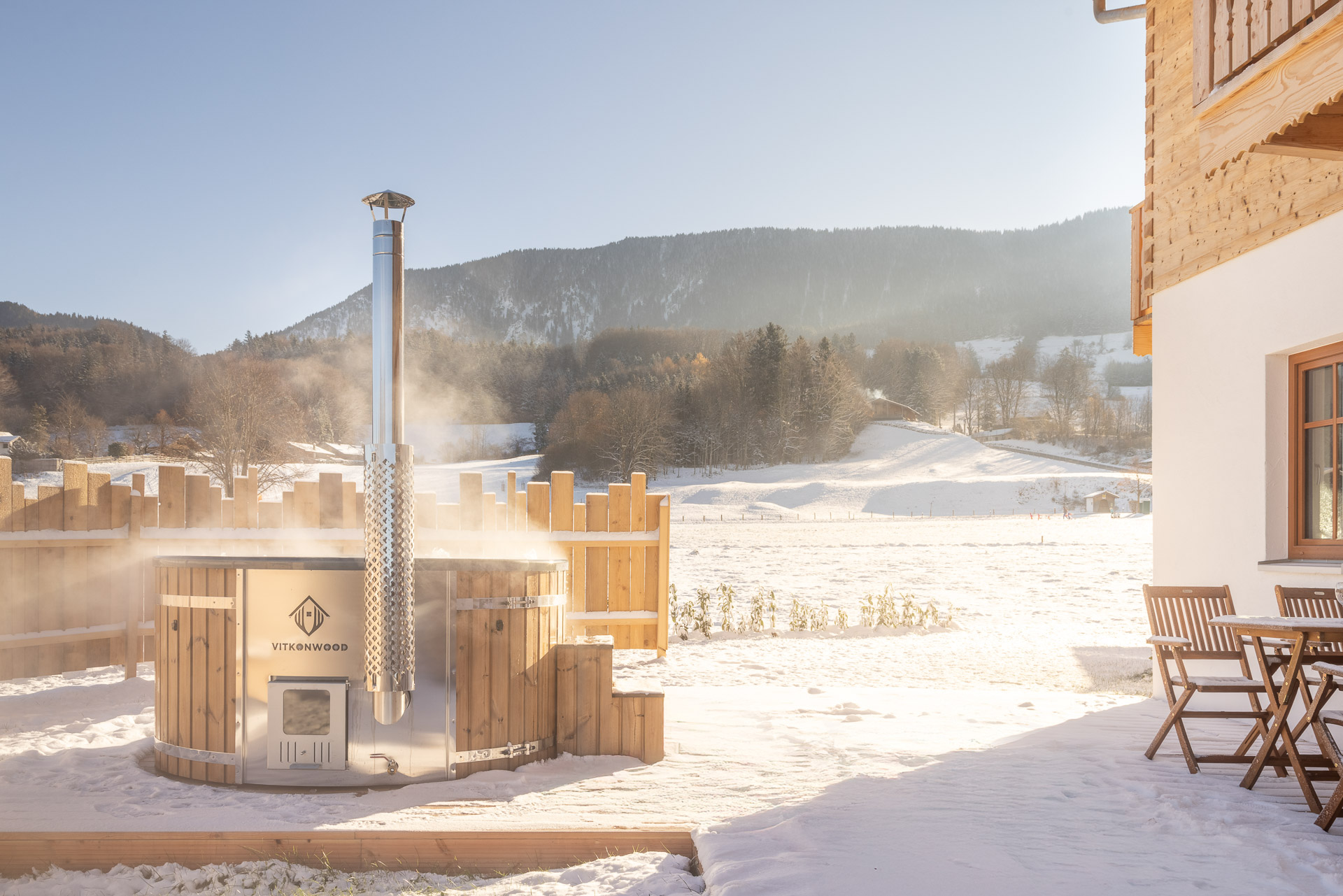 Hot Tub im Außenbereich der AlpenLodge Samerberg mit Blick auf die verschneite Berglandschaft