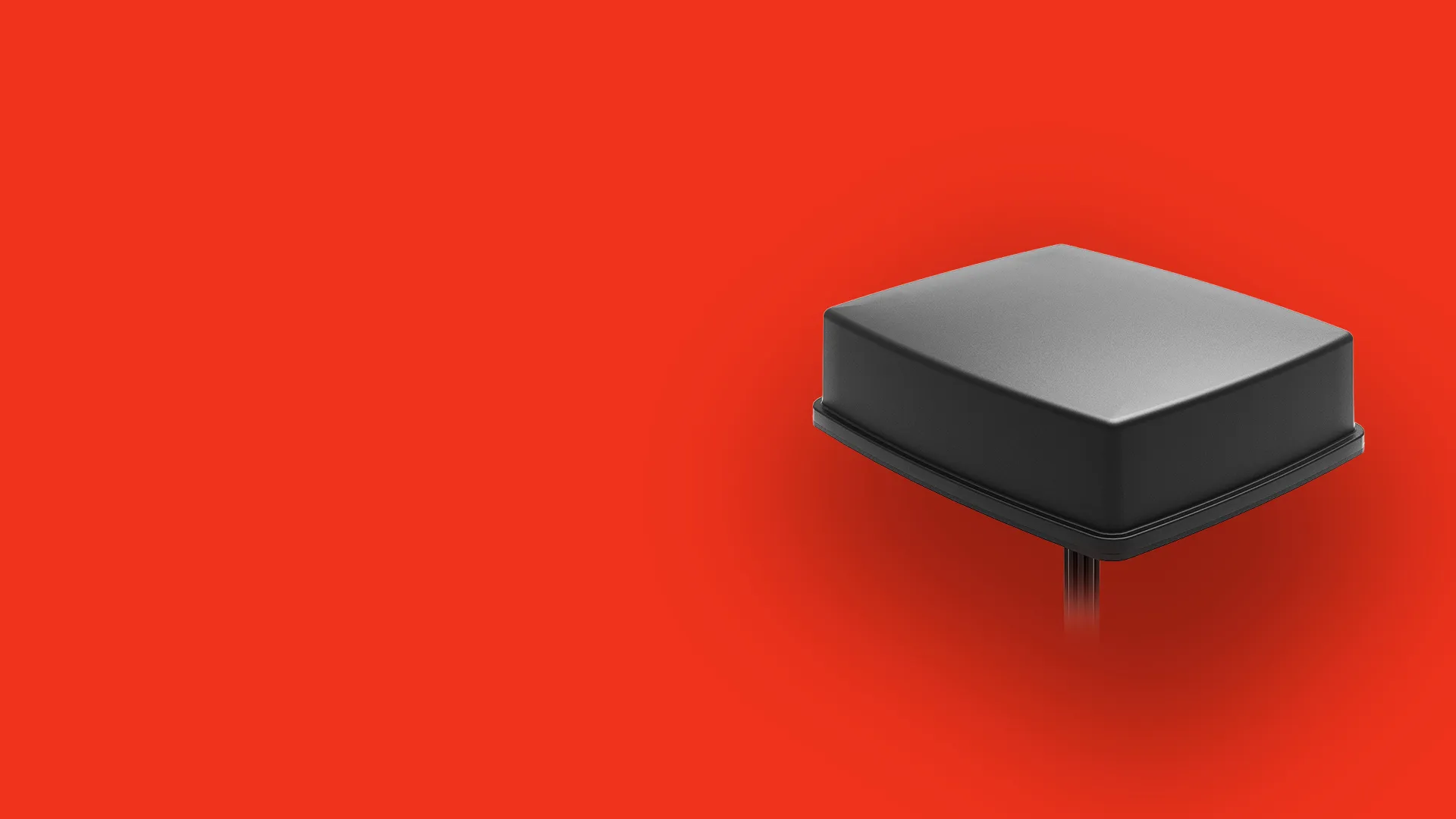 Black square-shaped electronic device with rounded edges mounted on a vertical stand against an orange background.