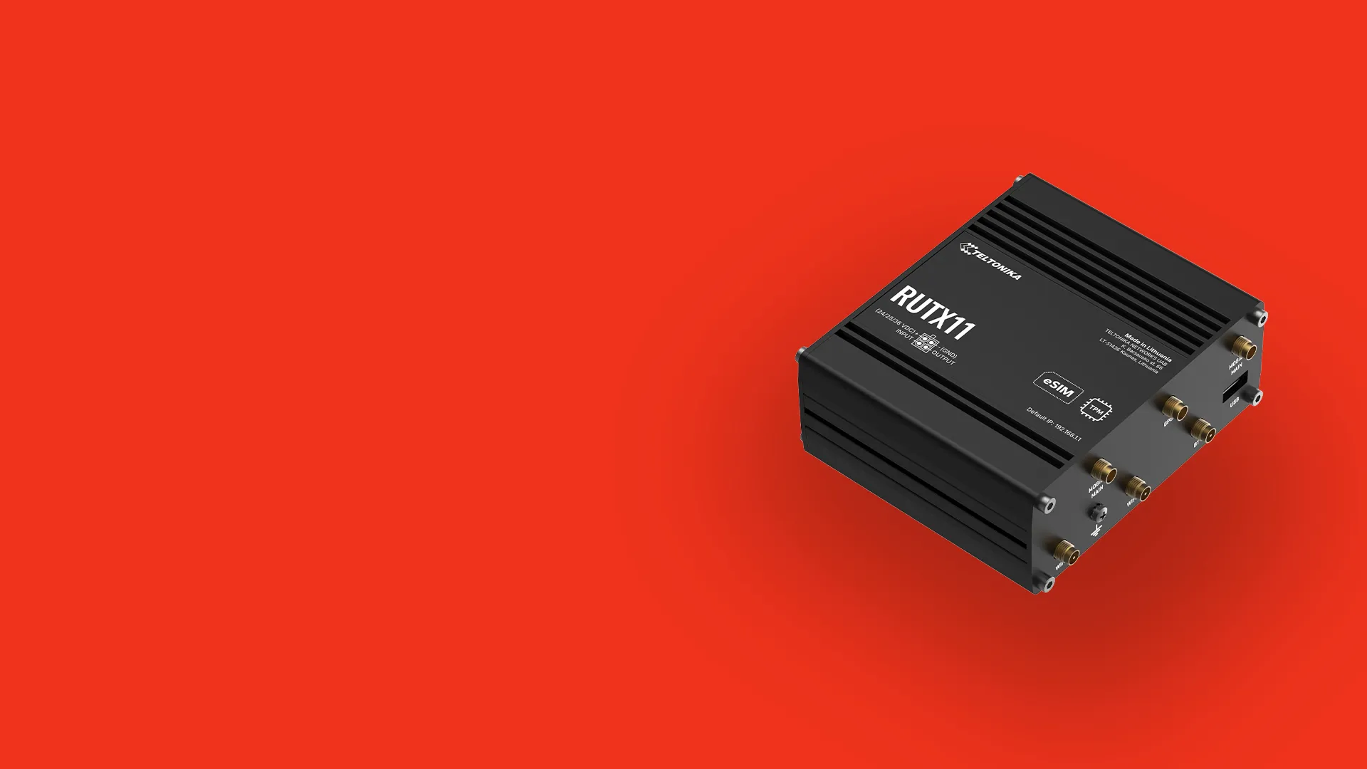 Black Teltonika RUTX11 industrial router with multiple antenna connectors on a red background.