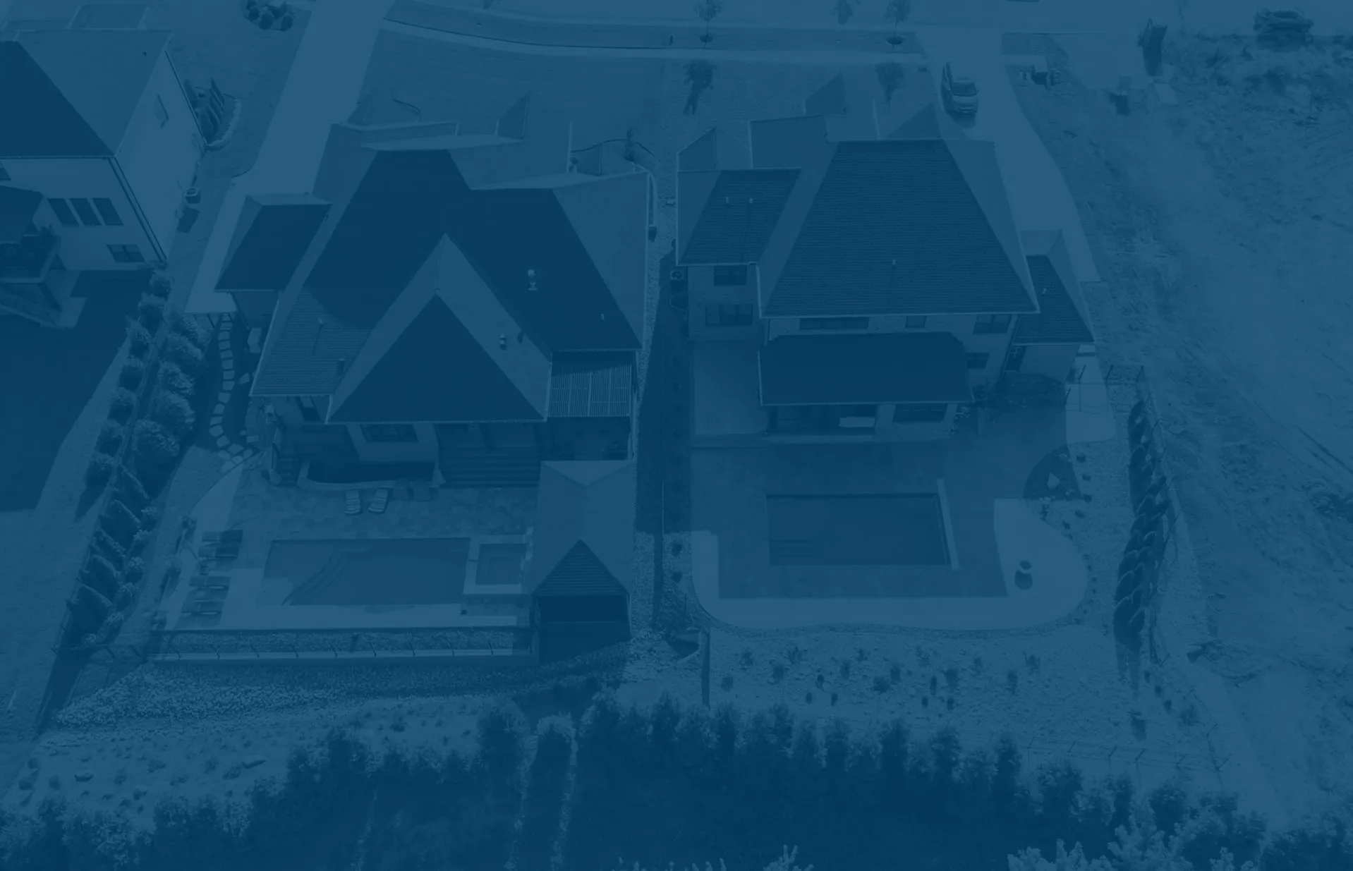 Aerial view of two modern houses each with a private swimming pool in the backyard and surrounding landscaping.