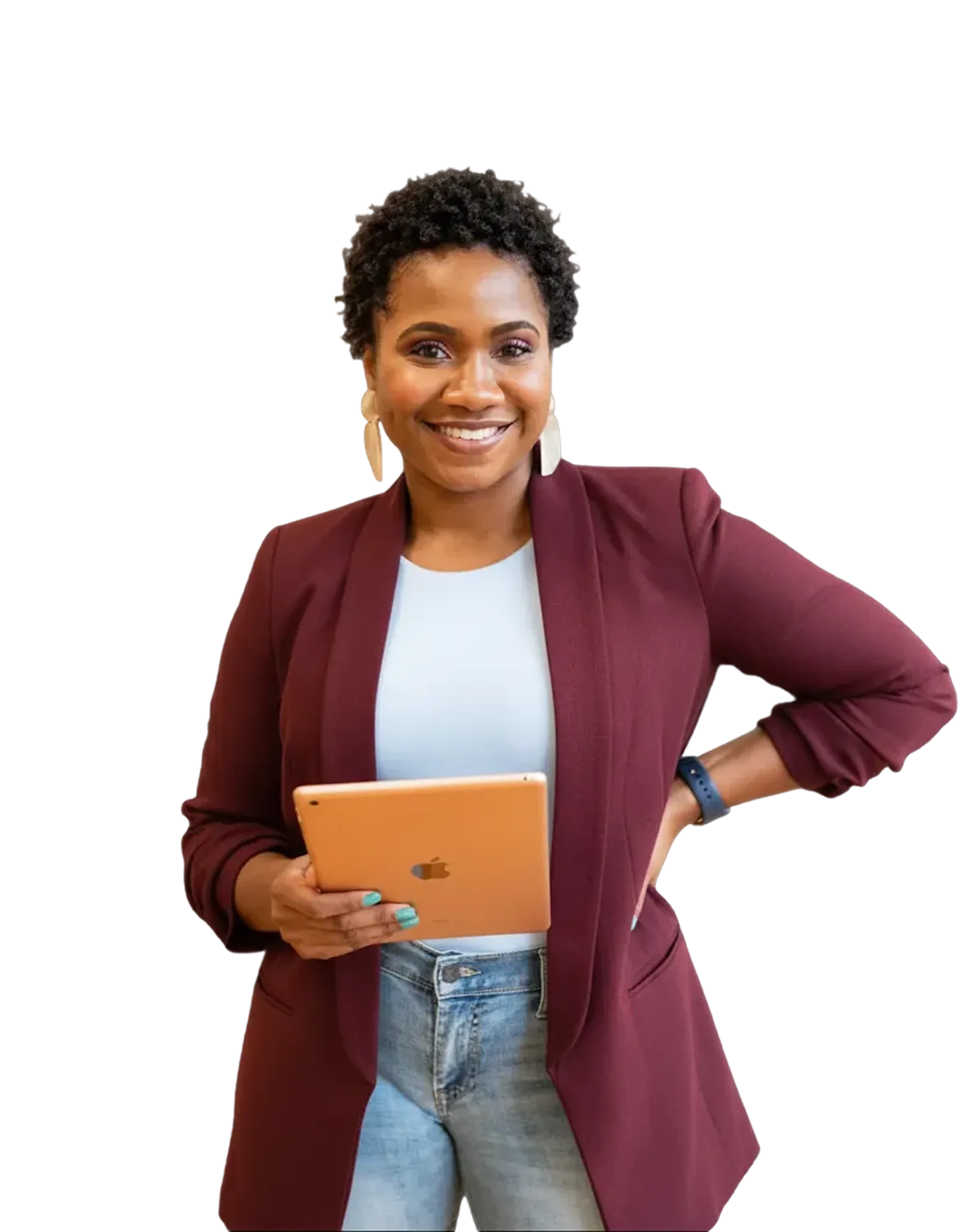 Smiling woman with short curly hair wearing a burgundy blazer, light blue top, and jeans holding a gold tablet.