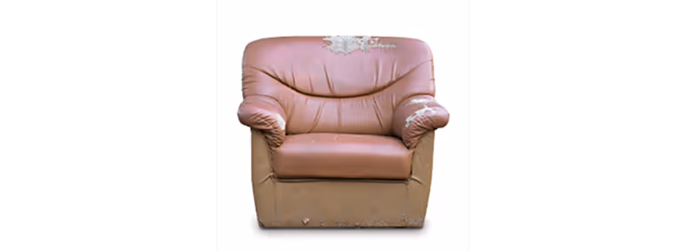 Old brown single-seat couch with tears in it