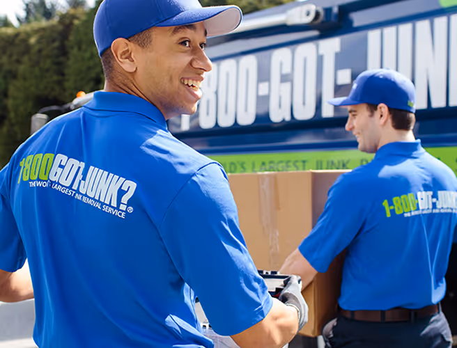 1-800-GOT-JUNK? team picking up junk to bring to junk removal truck