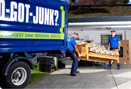 1-800-GOT-JUNK? team picking up old couch to put in junk removal truck