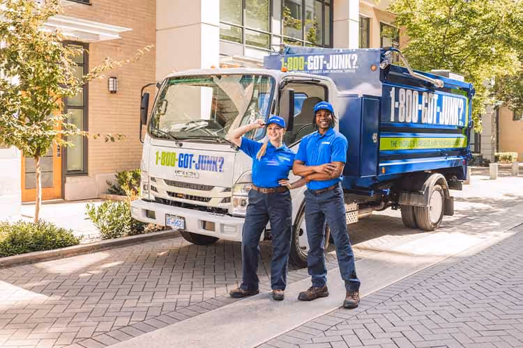 Two 1-800-GOT-JUNK team members standing in front of a branded truck