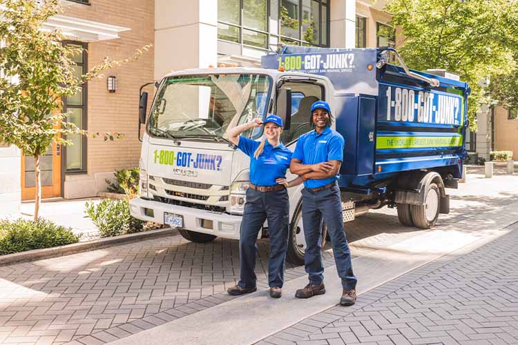 Two 1-800-GOT-JUNK team members standing in front of a branded truck