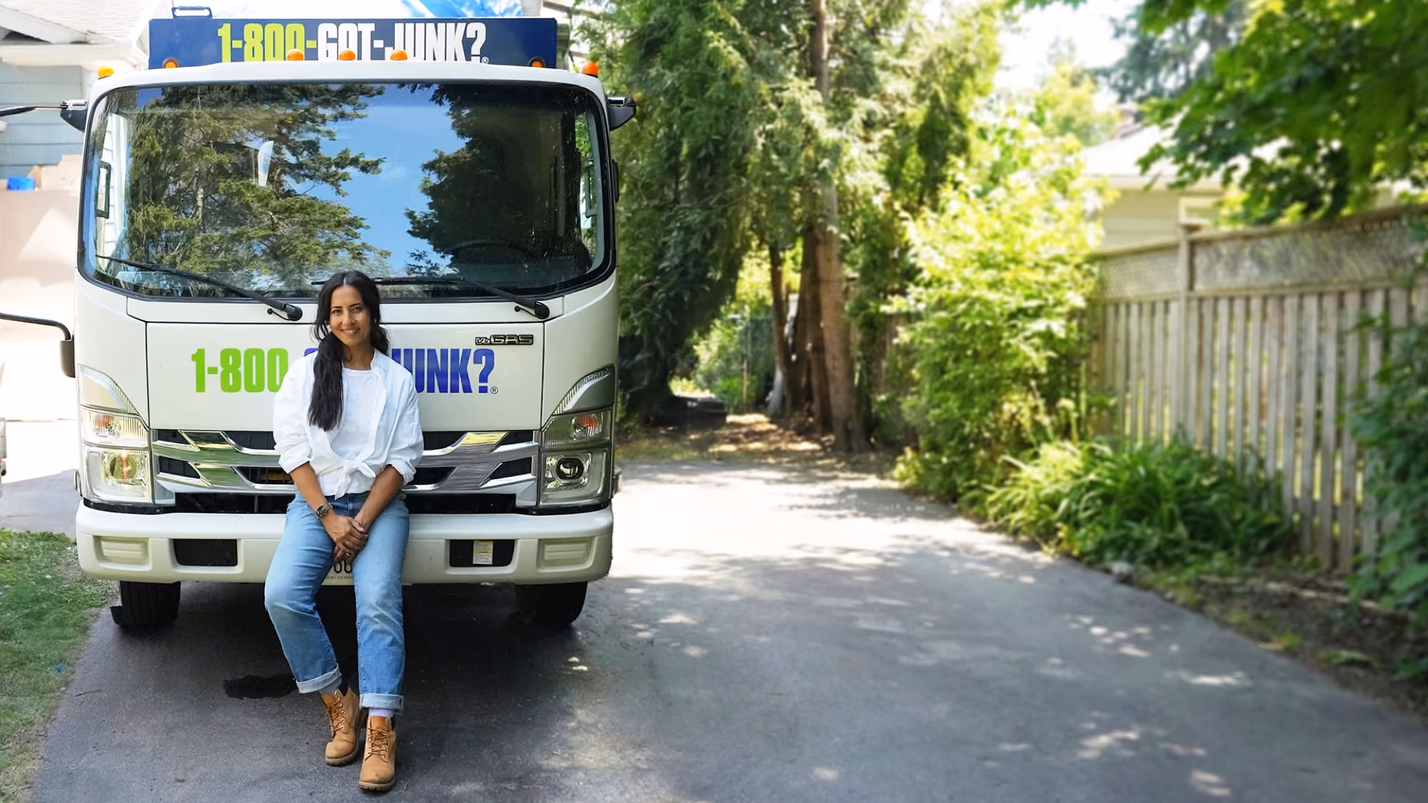 Meghan Yuri Young assise sur le pare-chocs d’un camion 1-800-GOT-JUNK?