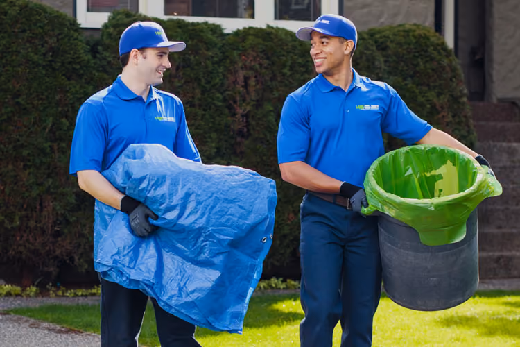 Two 1-800-GOT-JUNK? team members in front of a house