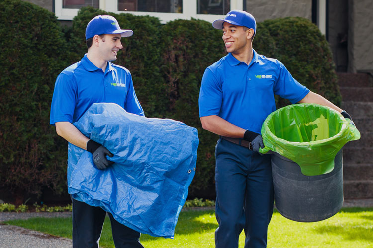 Two 1-800-GOT-JUNK? team members in front of a house