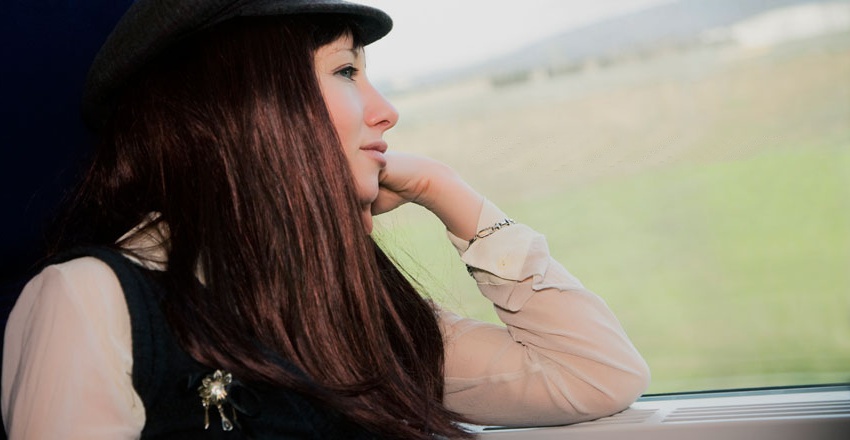 Jente ser ut vindu i tog.