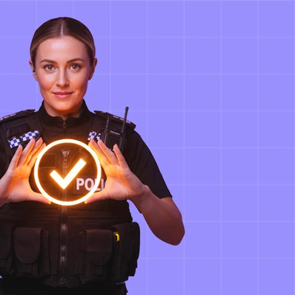 Female police officer in uniform holding a glowing orange checkmark symbol between her hands against a purple grid background.