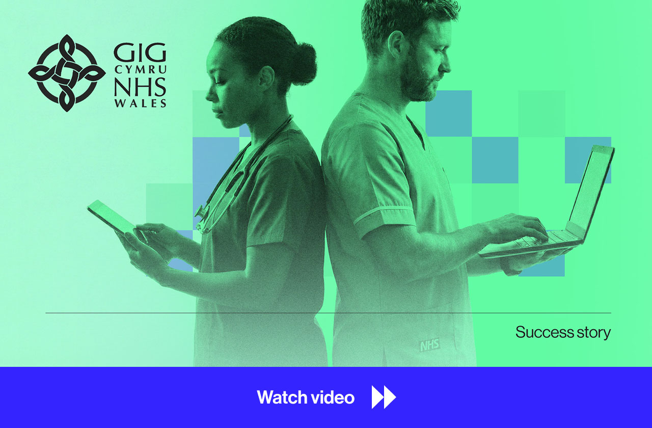 Two NHS Wales healthcare professionals standing back-to-back, one using a tablet and the other typing on a laptop, with the NHS Wales logo and text 'Success story'.