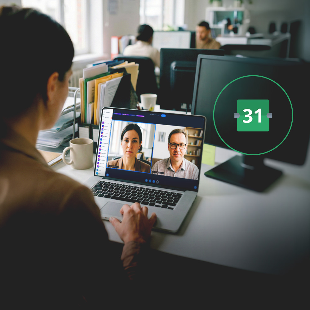 Person in an office on a video call with two colleagues on a laptop screen, with a calendar icon displaying the number 31 on a nearby monitor.