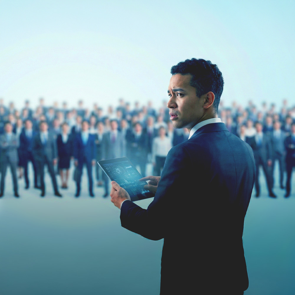 Businessman holding a digital tablet with holographic data, standing in front of a blurred crowd of professionals.