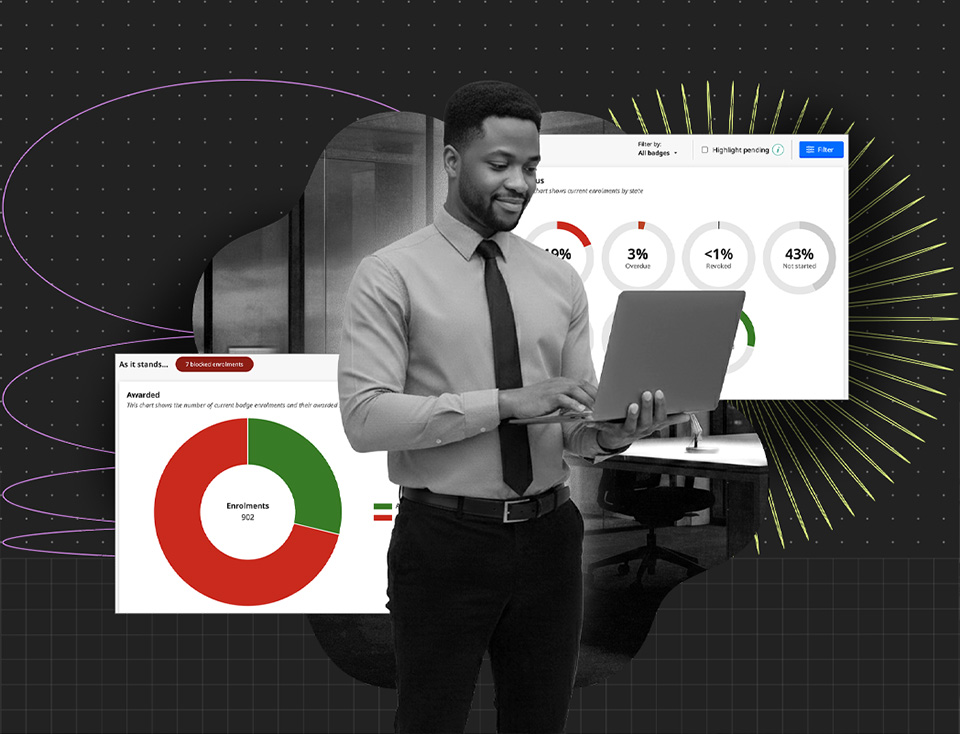 Man in dress shirt and tie using a laptop with data charts showing enrollment and badge statistics in the background.